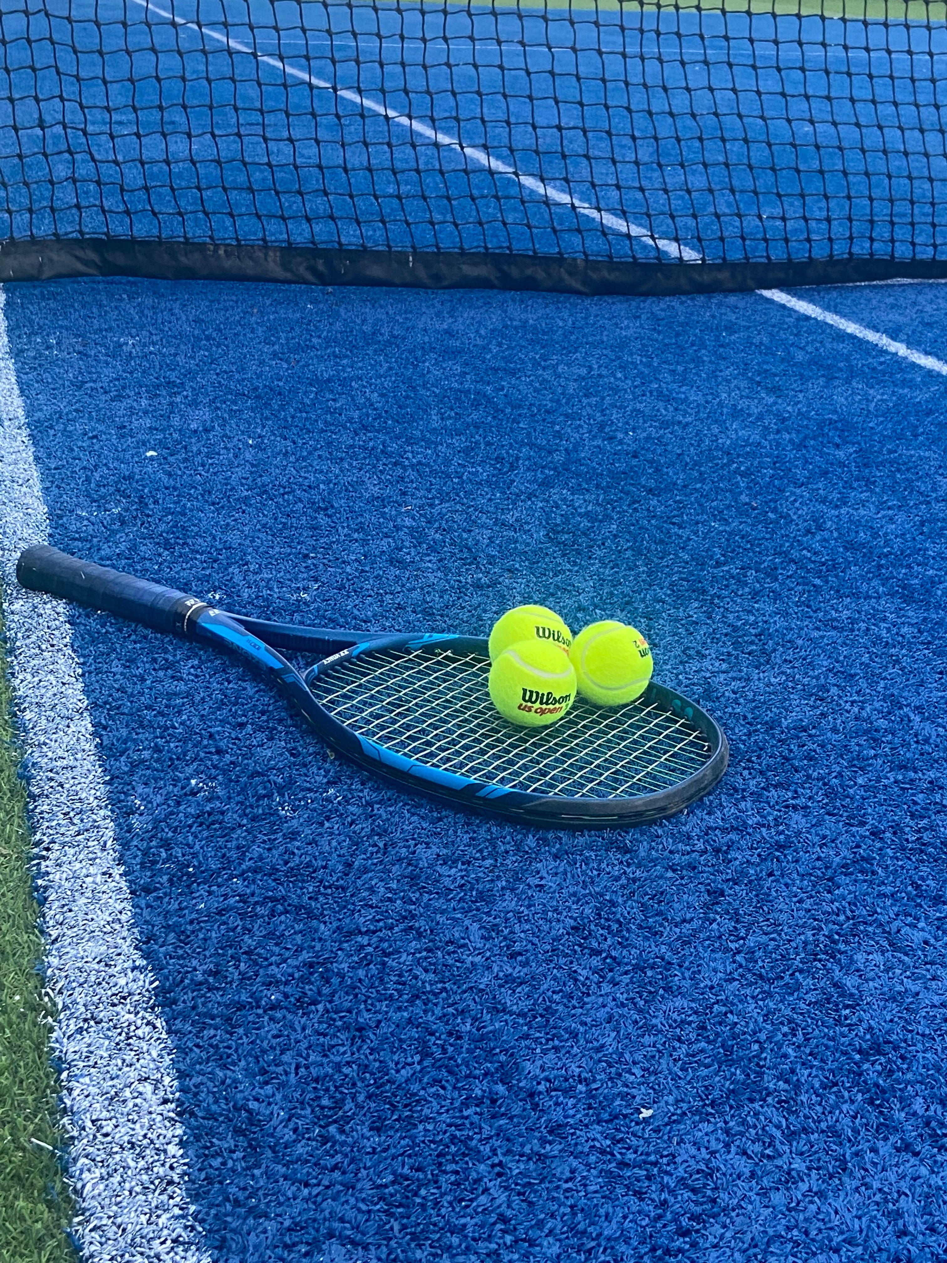 tennisracket met tennisballen op een padelbaan